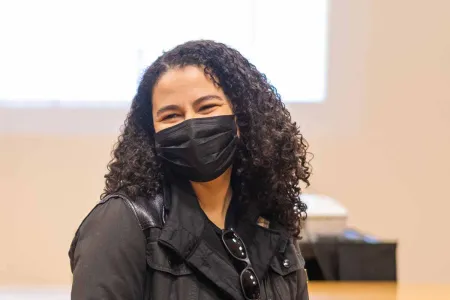 Bethany Collins sitting in a classroom in front of a slide projection