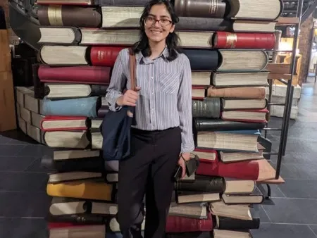 Foqia Sahid standing in front of books