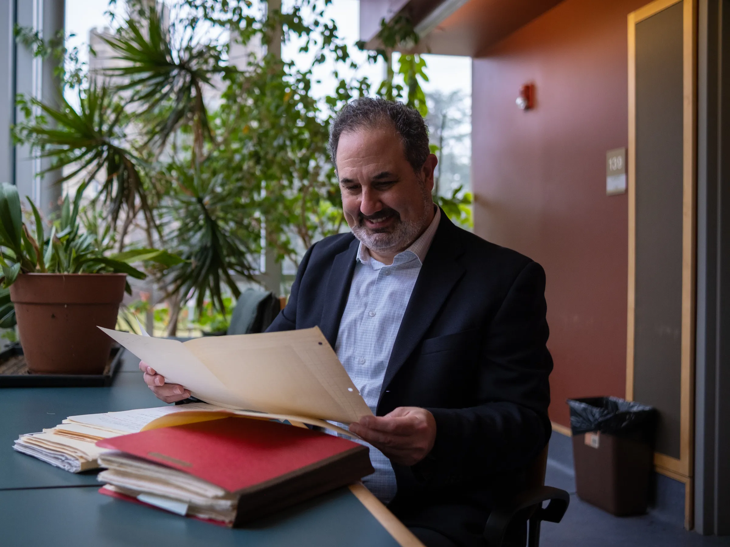 Marc Schulz smiling as he looks down at his files