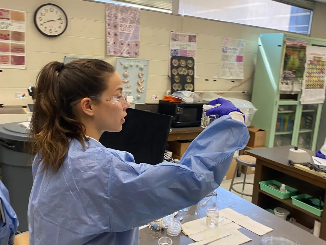 Leila in a lab coat and goggles