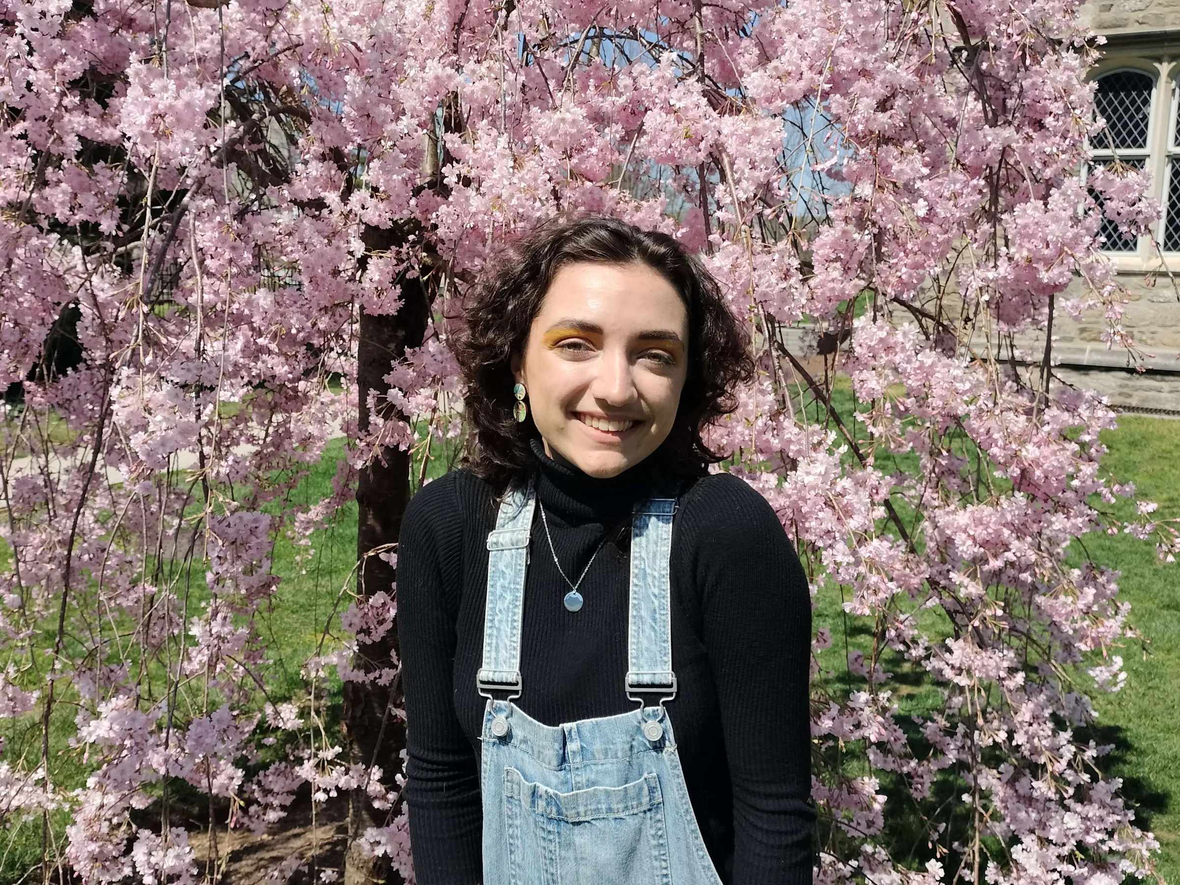 Arlowe Willingham in front of a cherry blossom tree. 