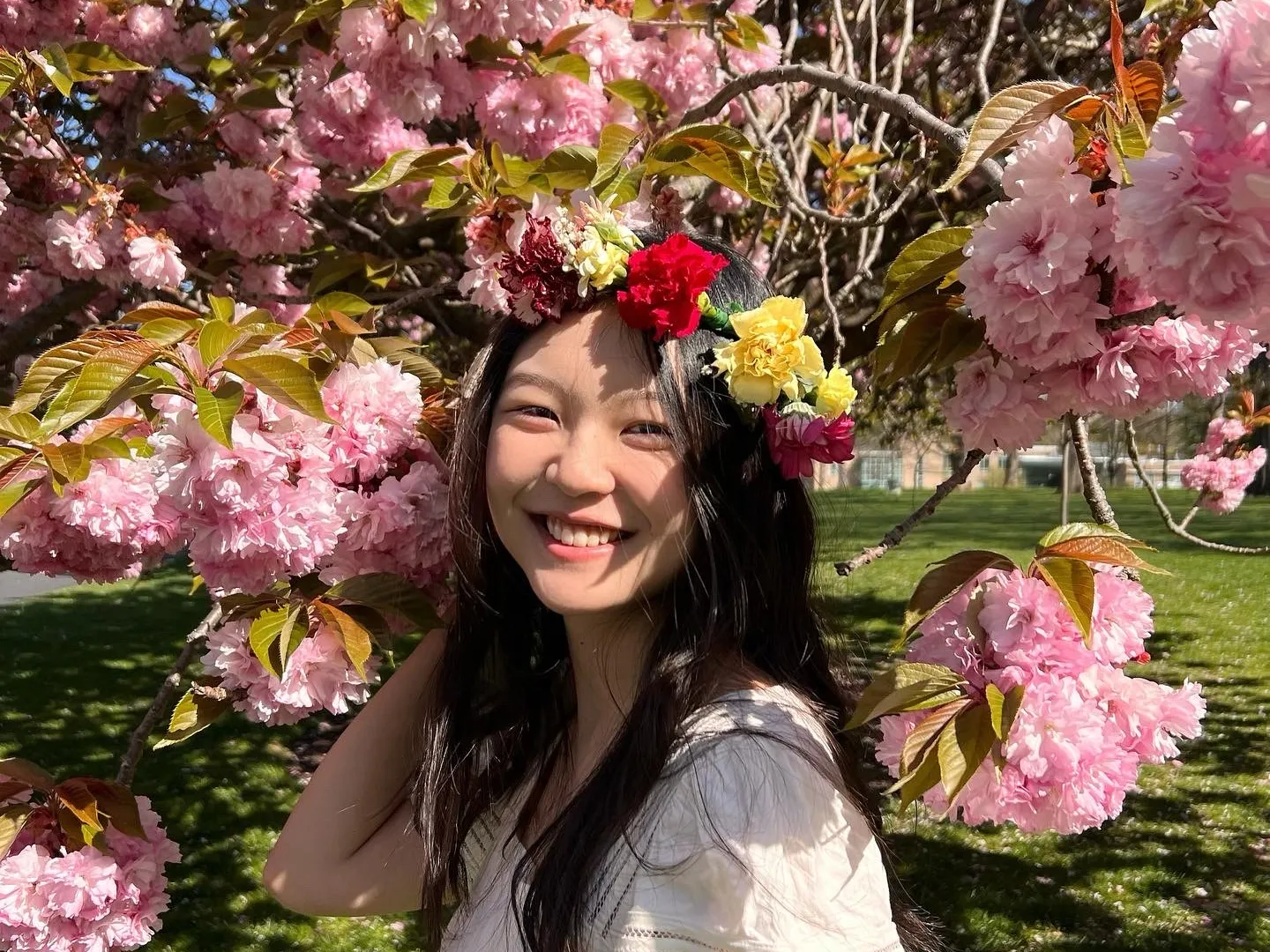 Sharon Liu in front of a cherry blossom tree. 