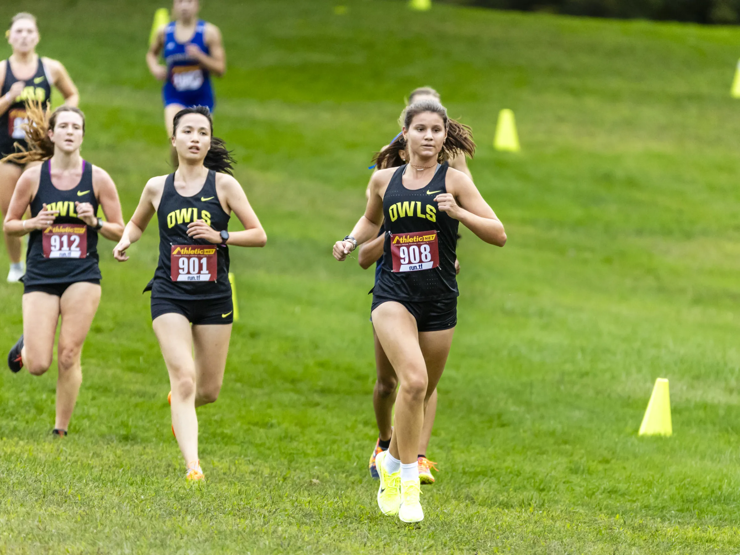 Students running on a grass field. 
