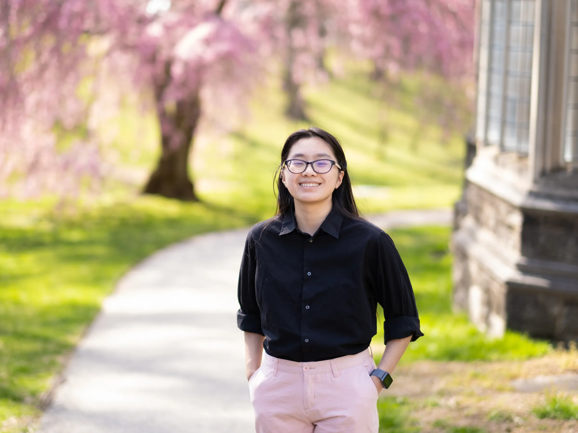 Glory Zhang in front of cherry blossom tree