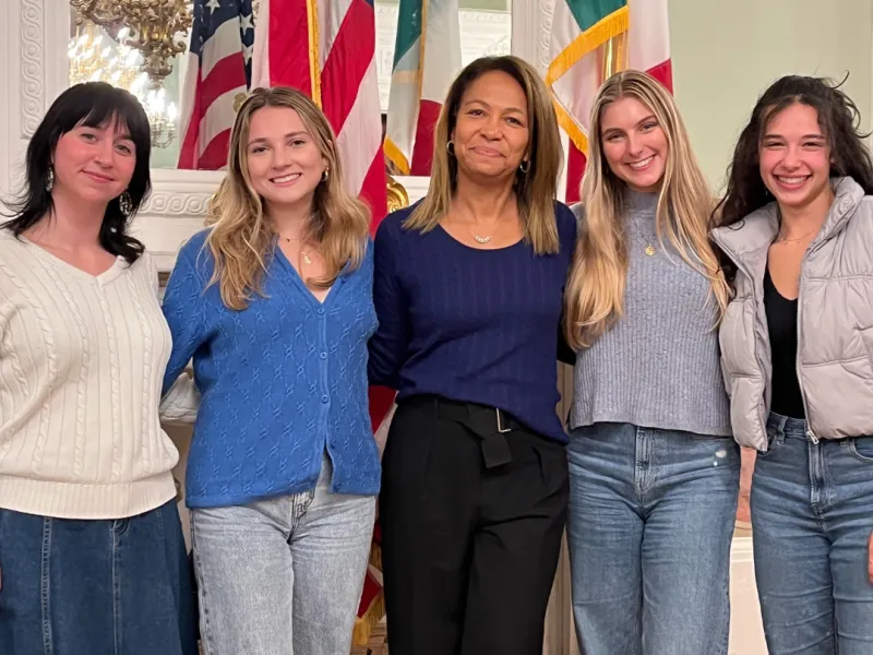 Group photo of four Bryn Mawr students and Daniela Ballard '90 in the US Consulate in Florence, Italy. 