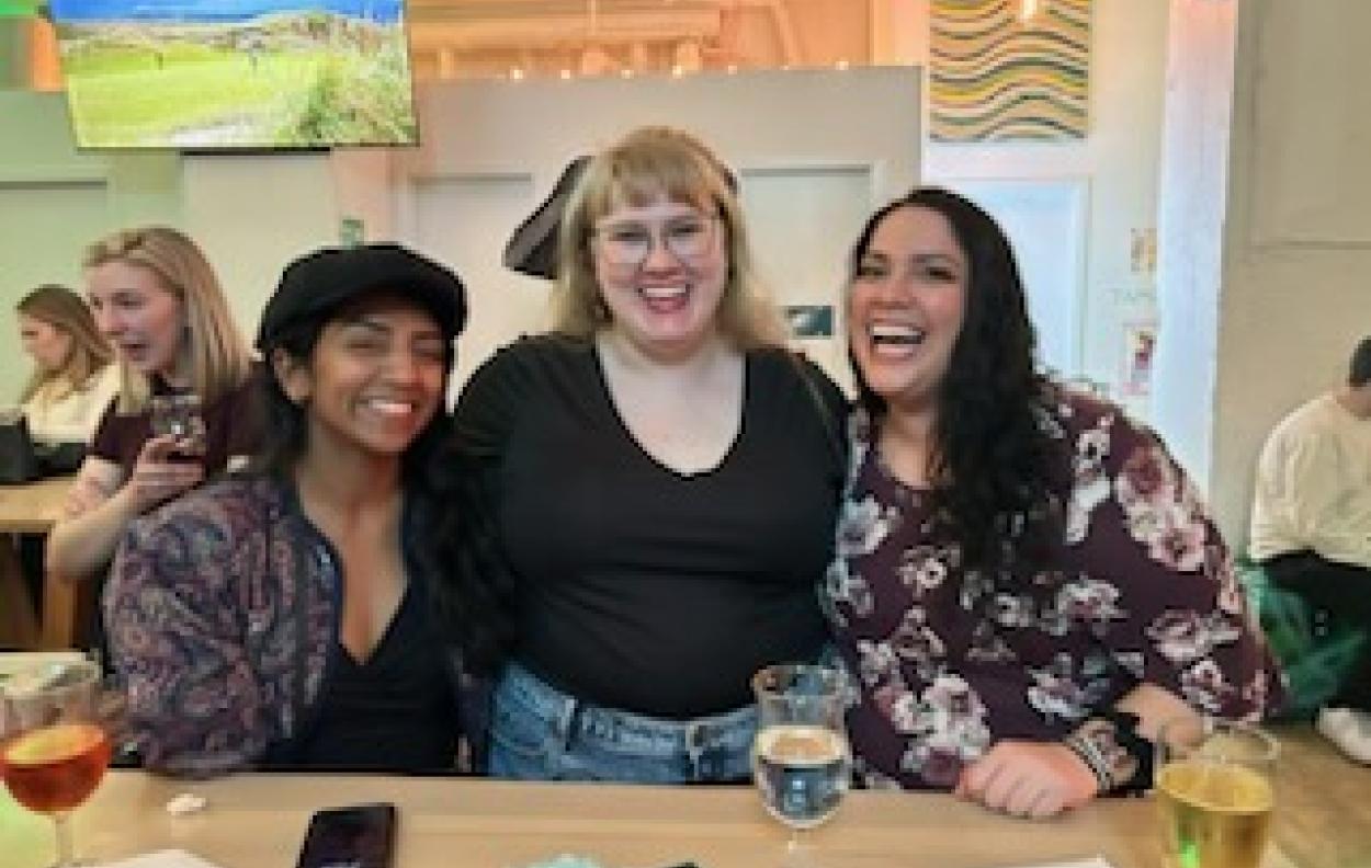 Three Mawrters smile together in a bar.