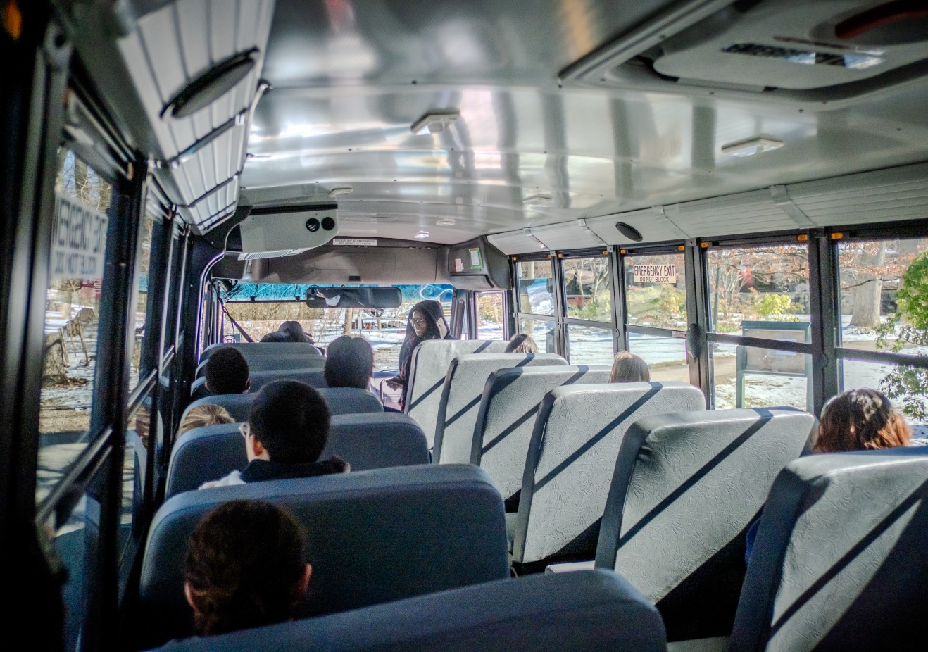 Students board the electric bus.