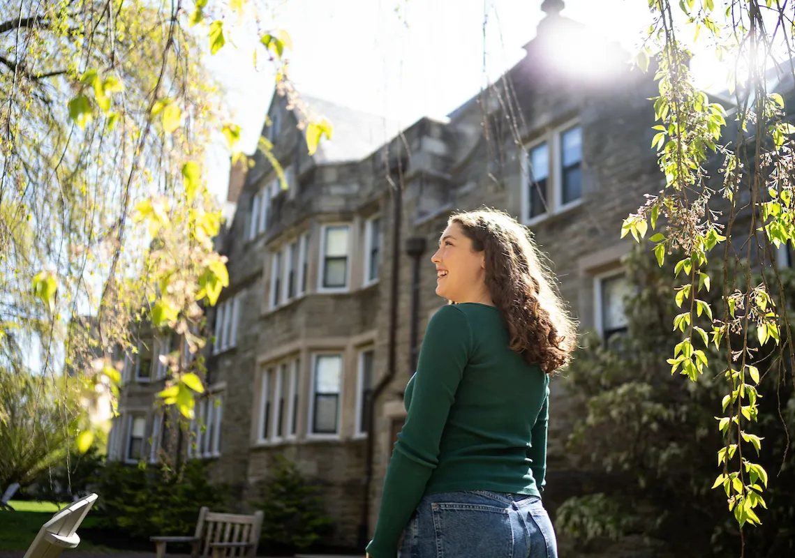 Student under tree smiling