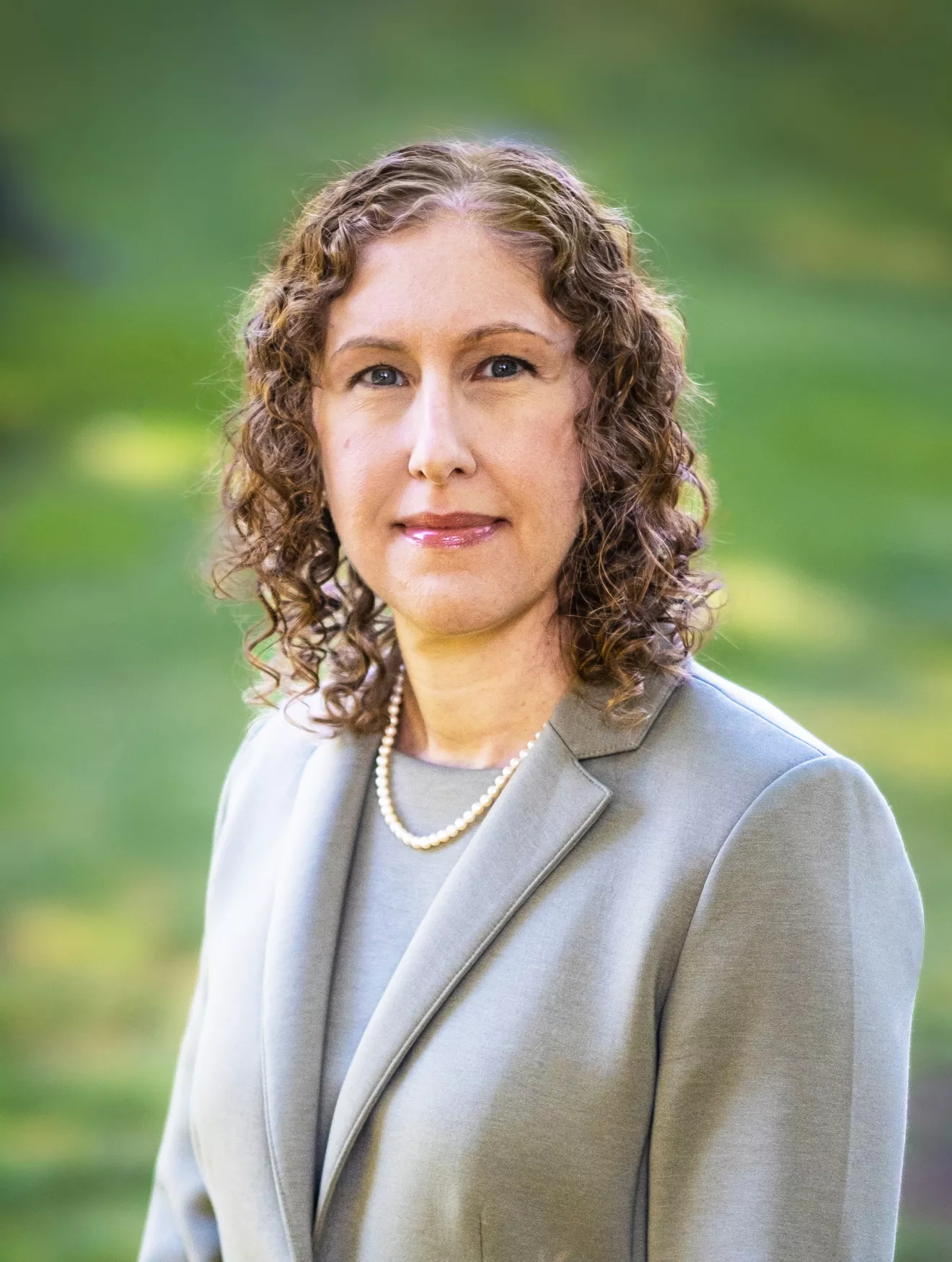 Brown haired woman in green suit