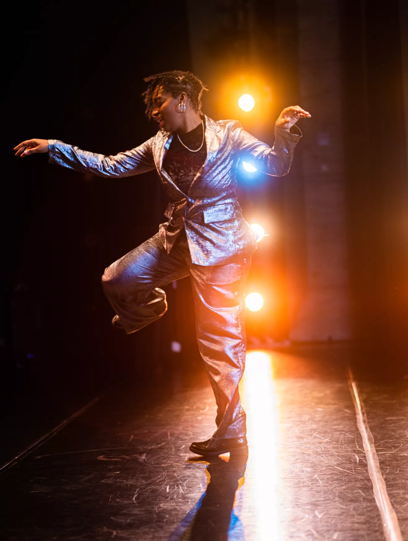 Lela Aisha Jones dancing in front of stage lights
