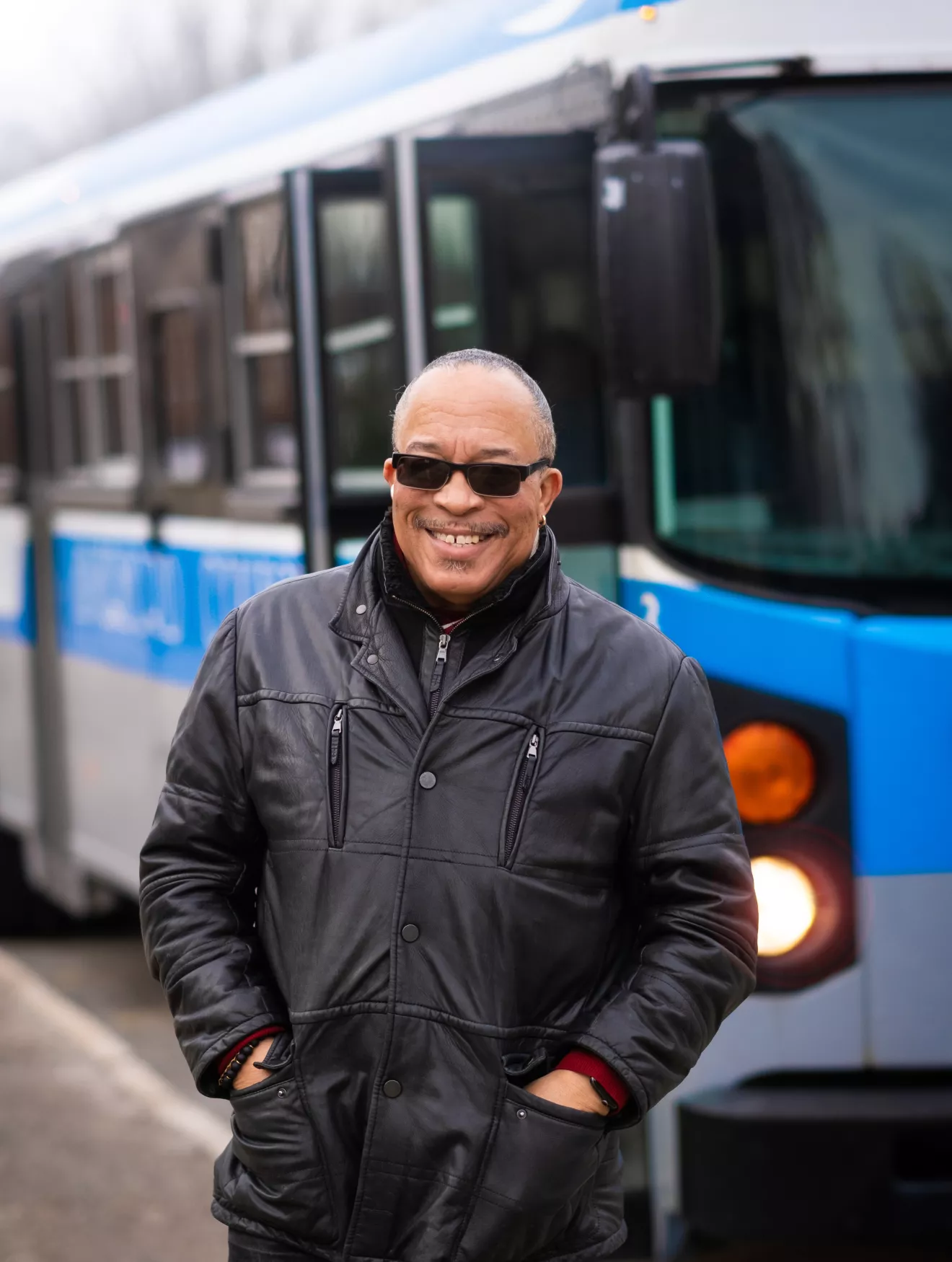 Steve Green smiling and posing in front of the Blue Bus