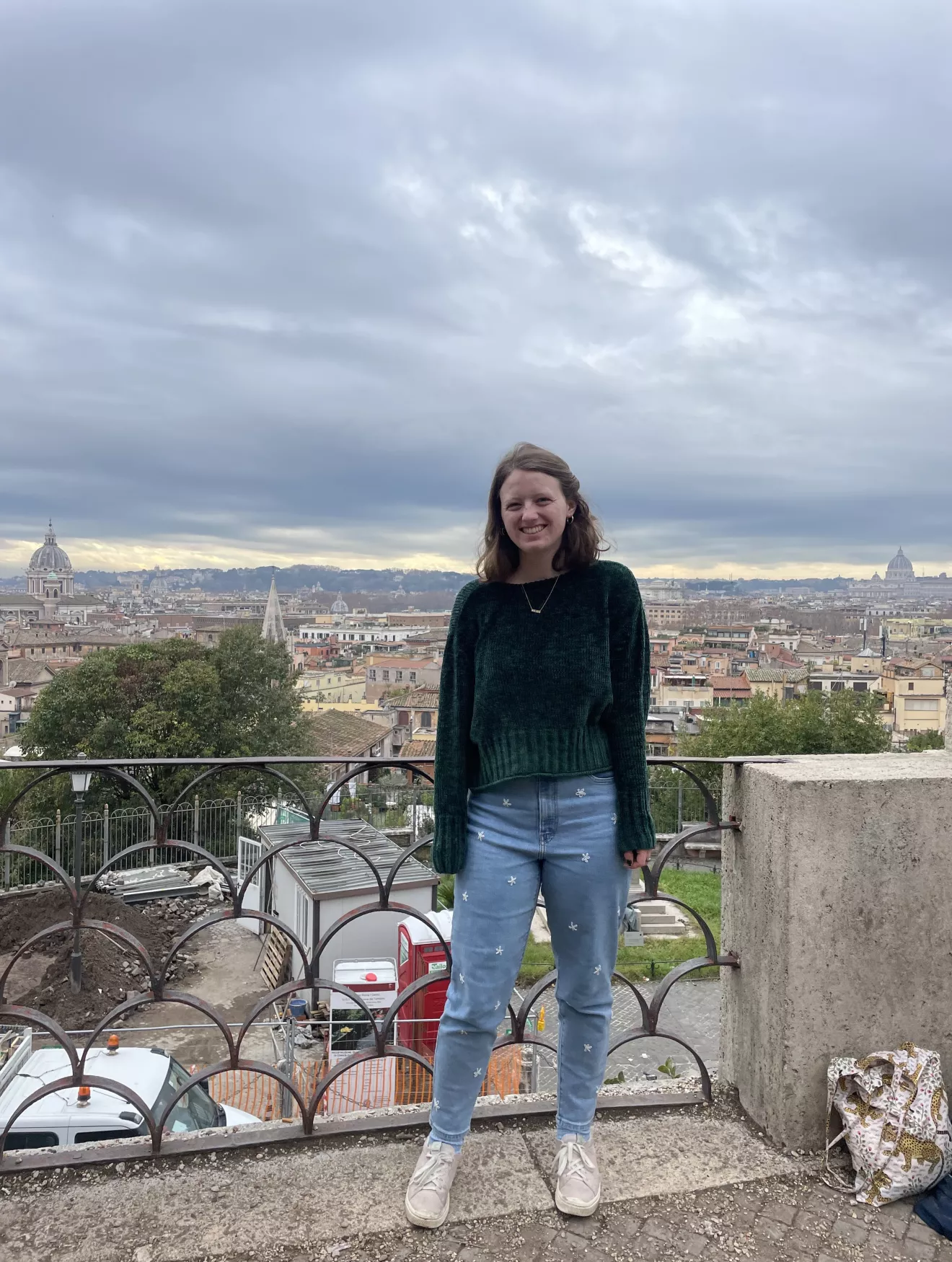 Ella Evans standing with a view of a city. 