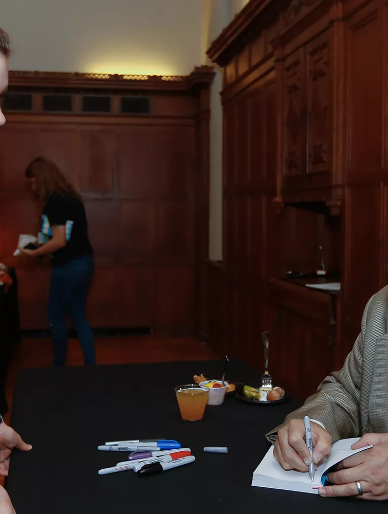 Adam Johnson signs a student's book