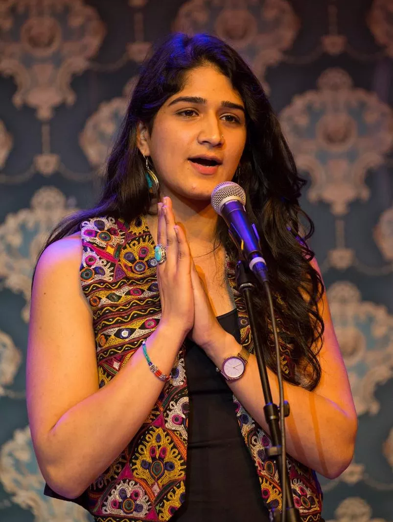 Sanam Sheriff '18 stands at a microphone as she performs her poetry