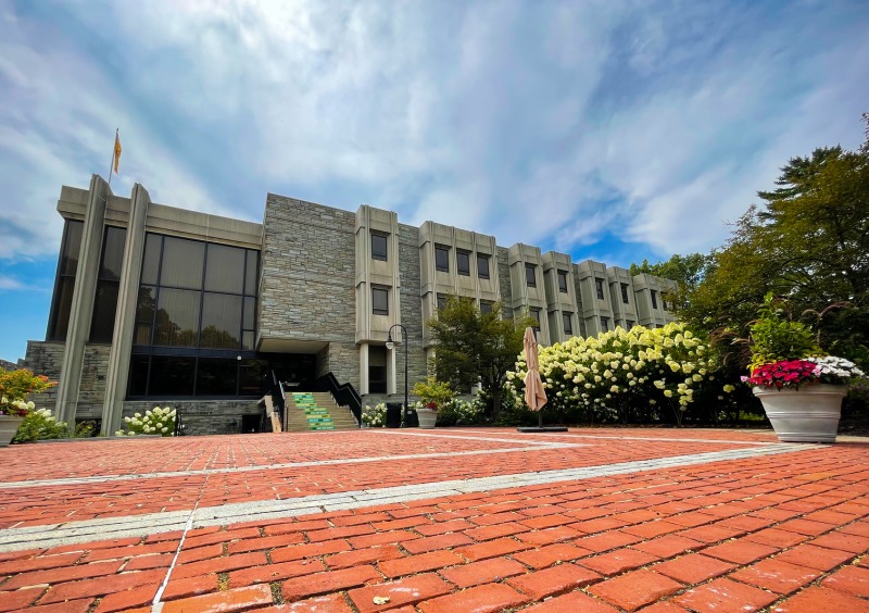 Brick walkway leading to three story stone building