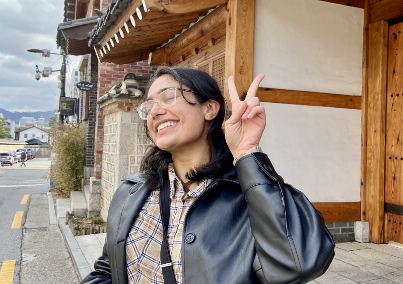 Aanandi Murlidharan posing with a peace sign outside of the Seoul Fortress