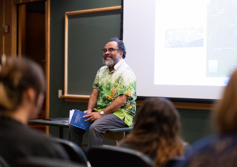 Ignacio Gallup-Diaz sitting on a table in a lecture hall