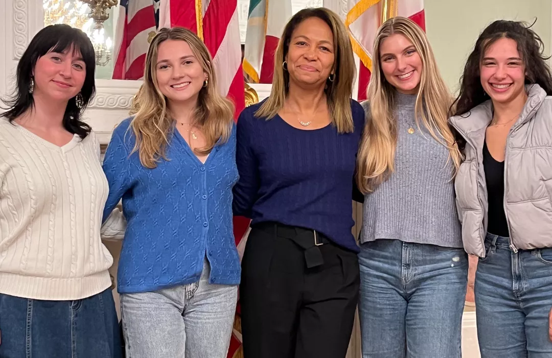 Group photo of four Bryn Mawr students and Daniela Ballard '90 in the US Consulate in Florence, Italy. 