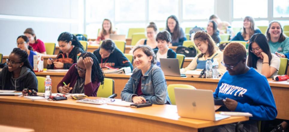 Students with laptops in a classroom learning