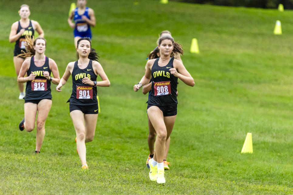 Students running on a grass field. 