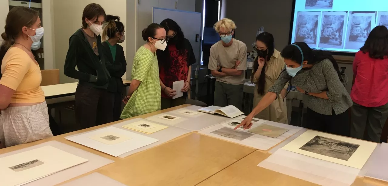 A group of students looking at art on a table