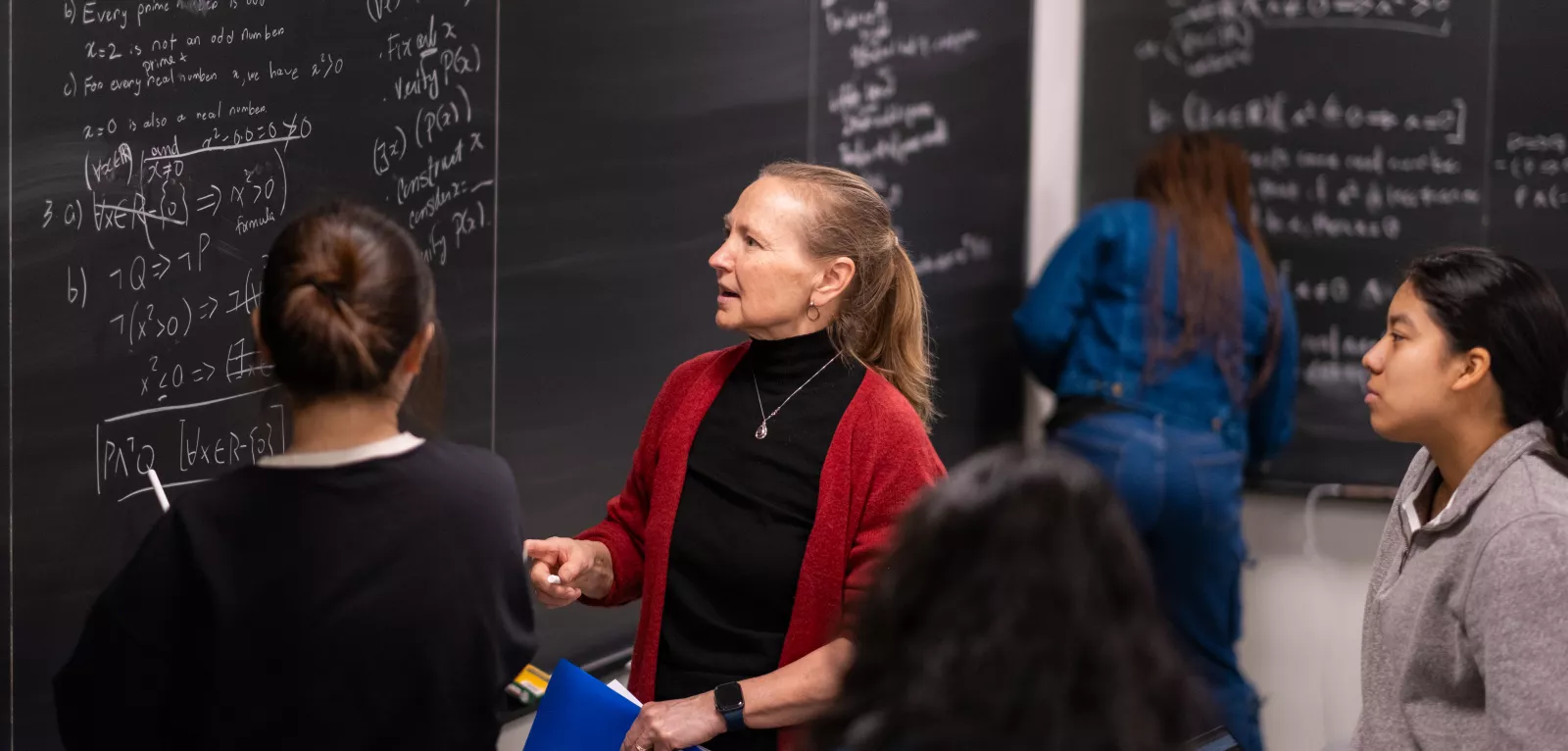 professor-lisa-traynor-teaching-students-math-at-chalkboard