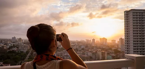 Student takes picture of sunset, shown from behind