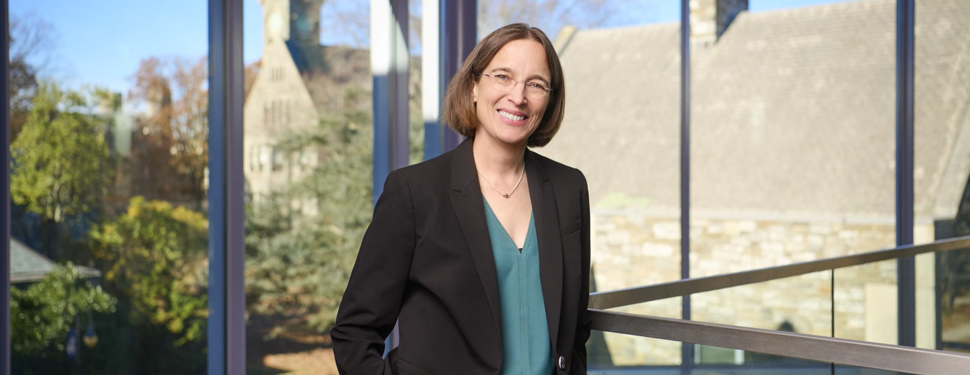 Woman in black suit in front of large window