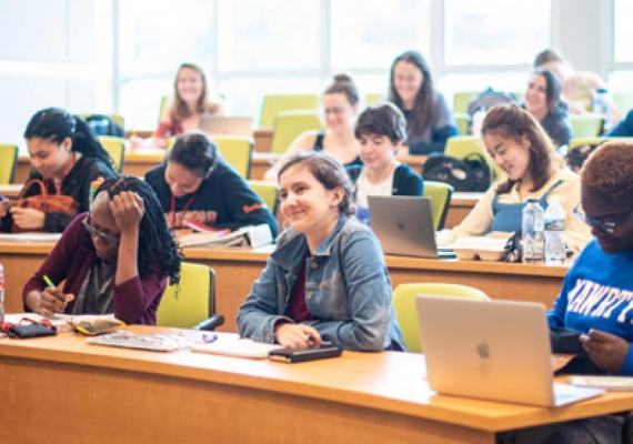 Students with laptops in a classroom learning