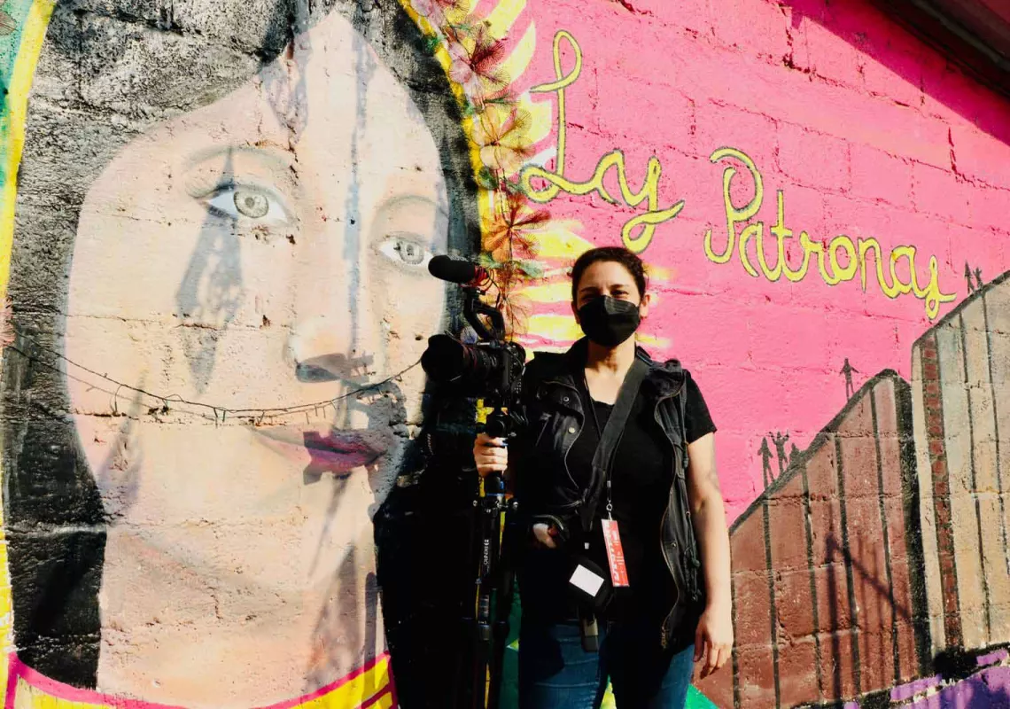 Tania Romero at Las Patronas, in front of a wall mural