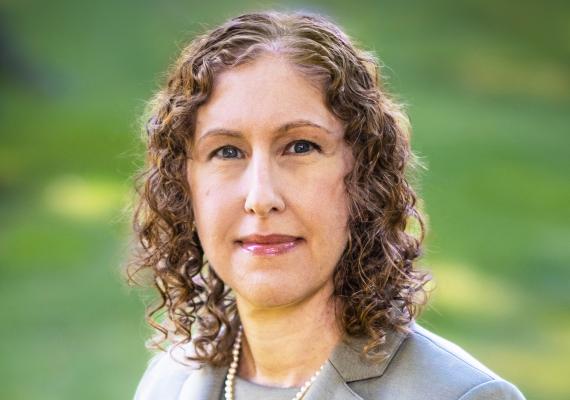 Brown haired woman in green suit