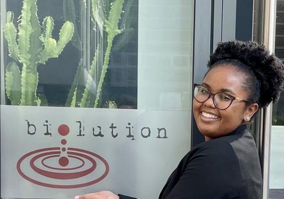 Whitney smiling next to a biolution sign