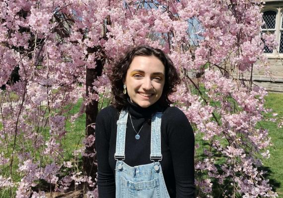 Arlowe Willingham in front of a cherry blossom tree. 