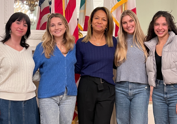 Group photo of four Bryn Mawr students and Daniela Ballard '90 in the US Consulate in Florence, Italy. 