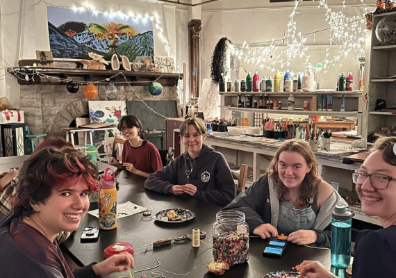 Students seated at a table working on crafts. 