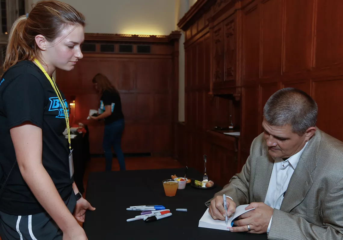 Adam Johnson signs a student's book