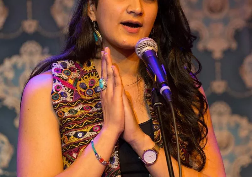 Sanam Sheriff '18 stands at a microphone as she performs her poetry