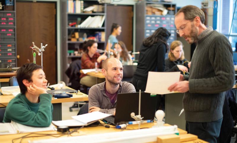 Three people are having a discussion in a lab