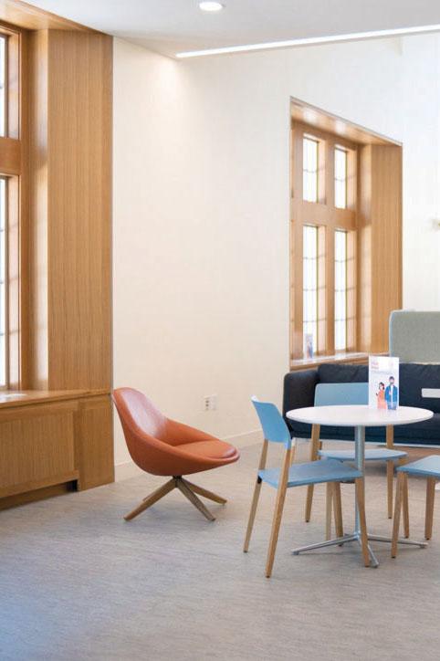 Interior of Student Life and Wellness Building, with focus on orange chair and a table