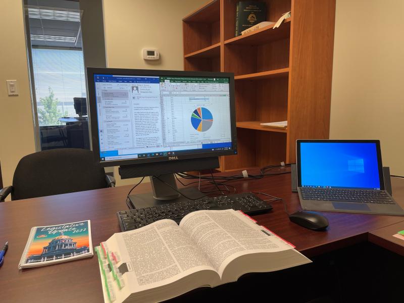 Desk with computer and textbook for Emma Ryan's internship