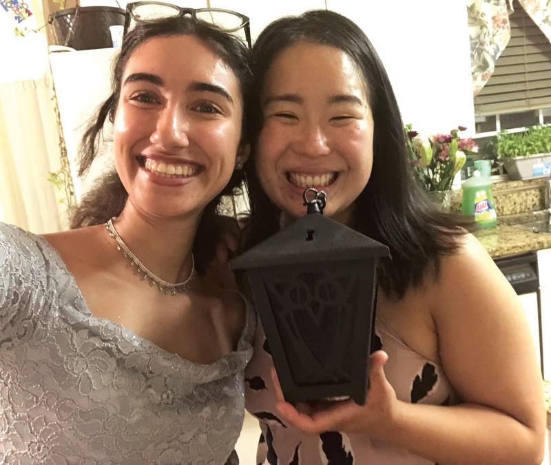 Dounya Ramadan and Lizzy Lee standing together, holding a lantern