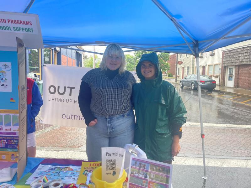 Alex Barstow and a OUT Maine Coordinator standing side by side and smiling under an outdoor tent