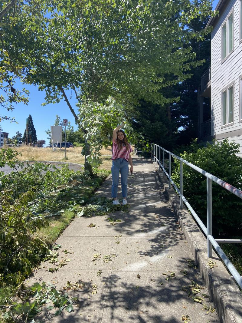 Camille holding a bundle of tree branches. 