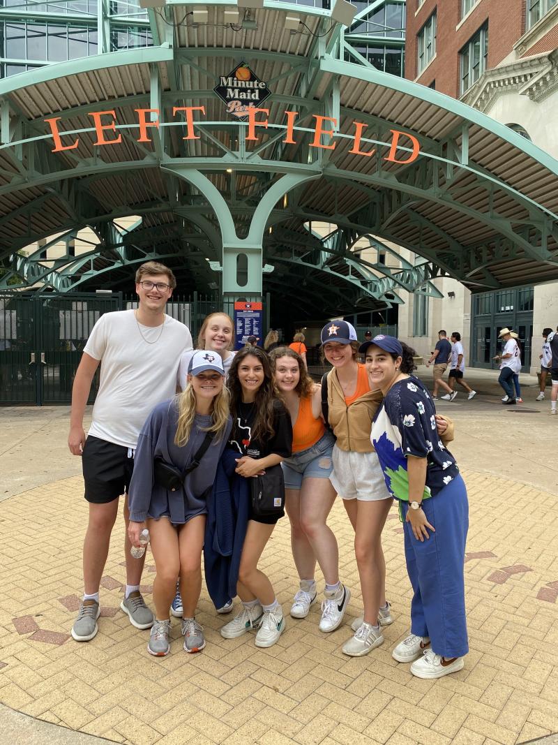 Group photo in front of a stadium entrance. 