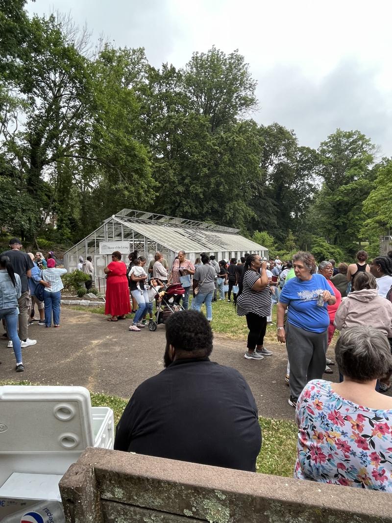 People in front of a greenhouse. 