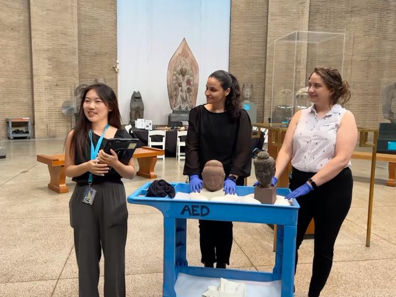 Three people in a museum. 