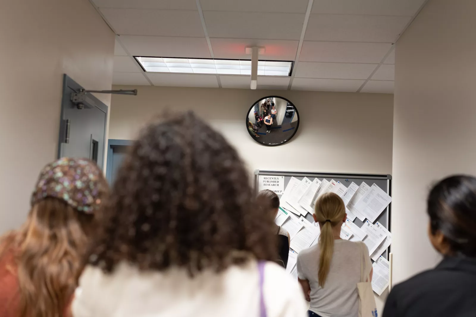 Back of a group of people in a hallway.