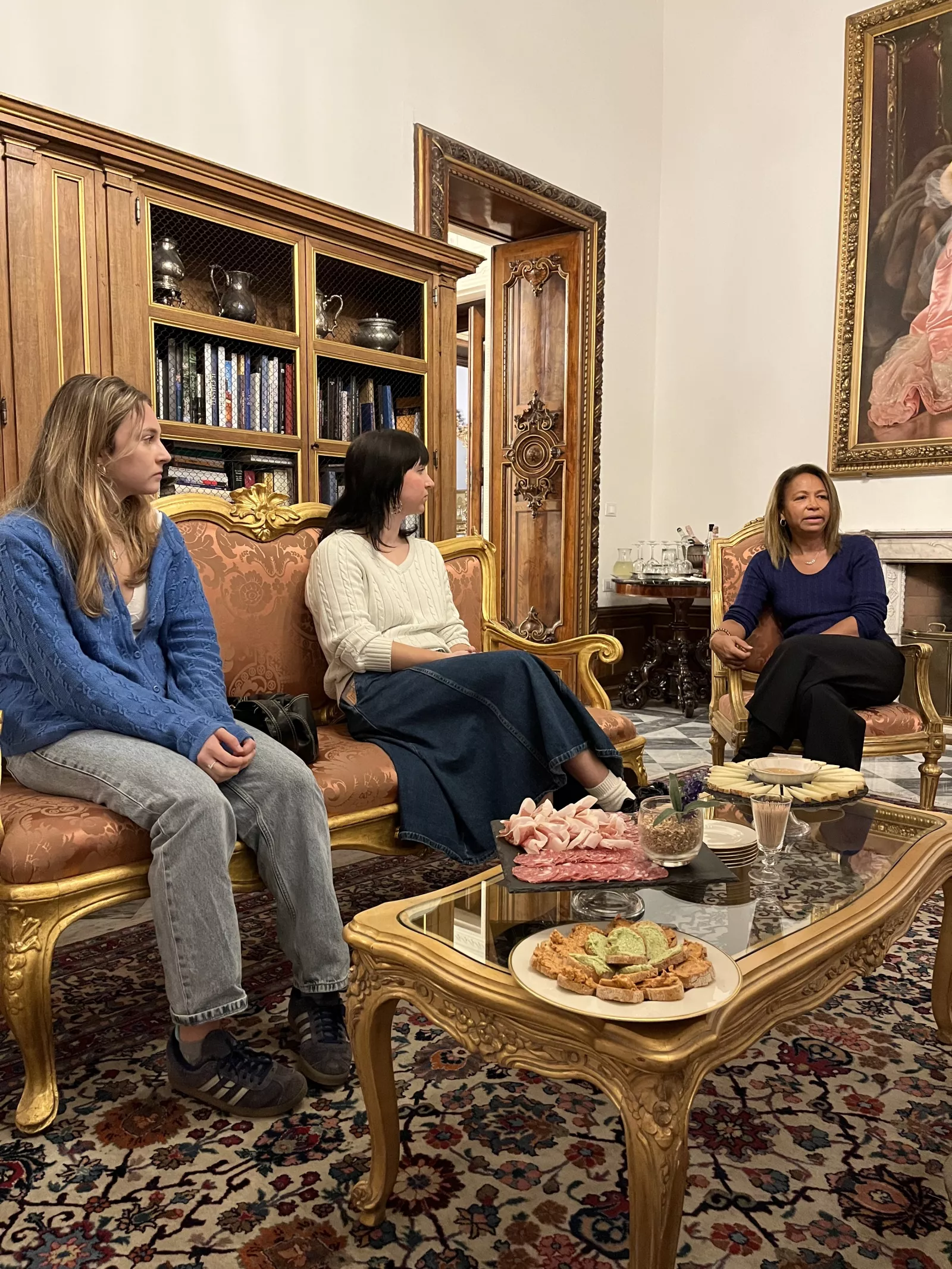 Two Bryn Mawr students and Daniela Ballard seated around a coffee table. 