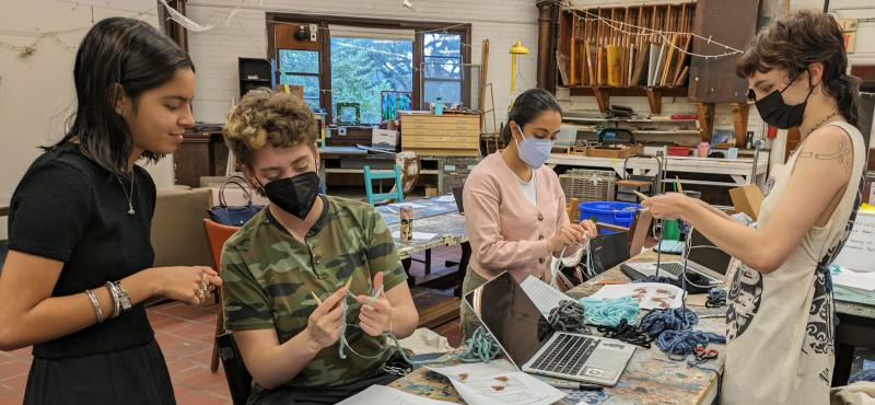 Students work on tapestries representing sulfur dioxide emissions from coal-fired power plants