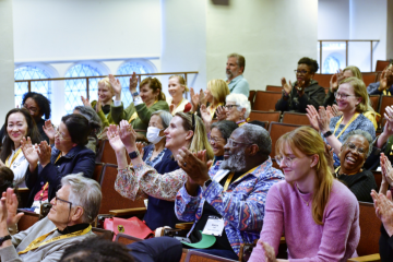 Group of people clapping in a lecture hall